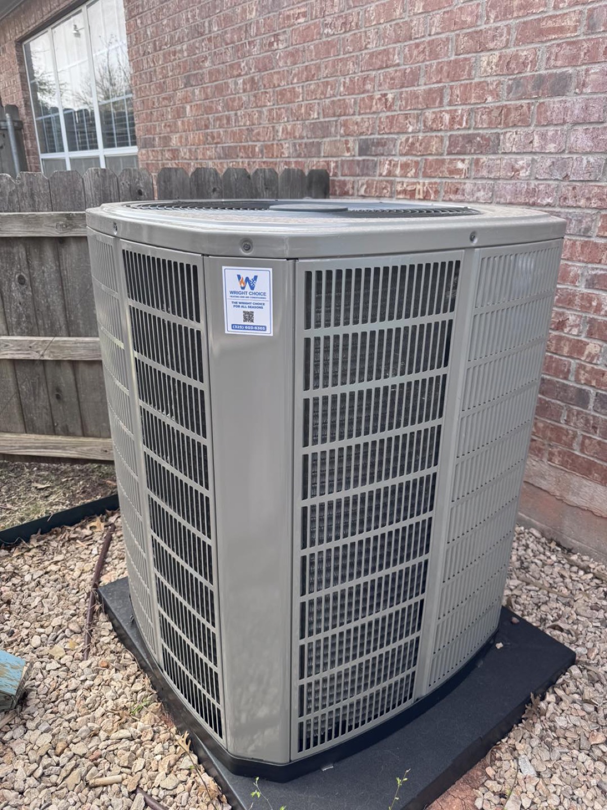 American Standard AC condenser with a Wright Choice sticker against brick installed in West Texas
